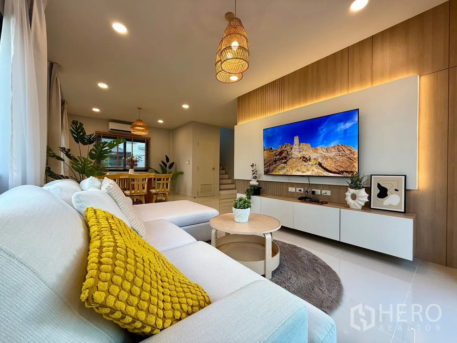 Detached House for rent in Bang Phli, Samut Prakan - Living area with feature TV wall, sofa and view toward dining zone.