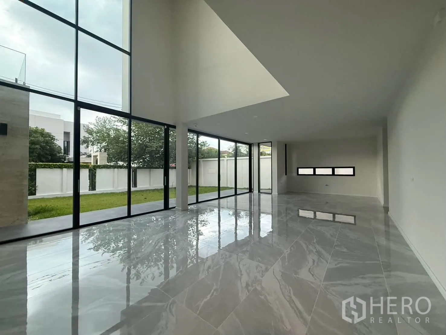 บ้านเดี่ยว for rent in Bang Khen, Bangkok - ห้องนั่งเล่นเพดานสูงกระจกเต็มบานเชื่อมสู่สนามหญ้า