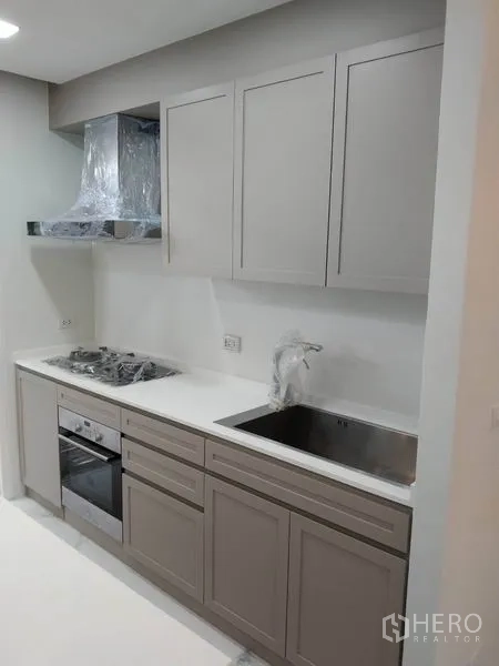 Townhouse for rent in Yan Nawa, Bangkok - Fitted kitchen with hob, oven, extractor and upper cabinets.