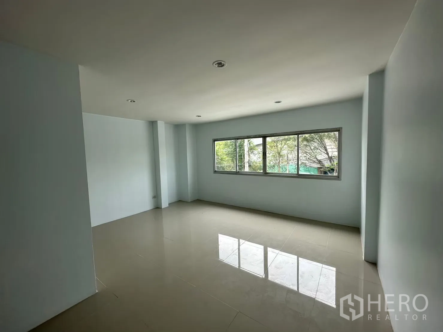 Factory for rent in Bang Bua Thong, Nonthaburi - Large office space with a wide window overlooking greenery.
