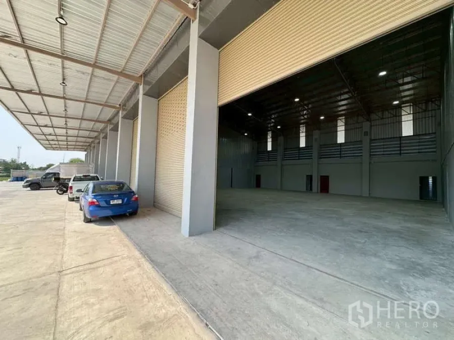 Warehouse for rent in Bang Phli, Samut Prakan - Covered loading bay with multiple roll-up doors and a wide driveway at a modern warehouse in Bang Phli