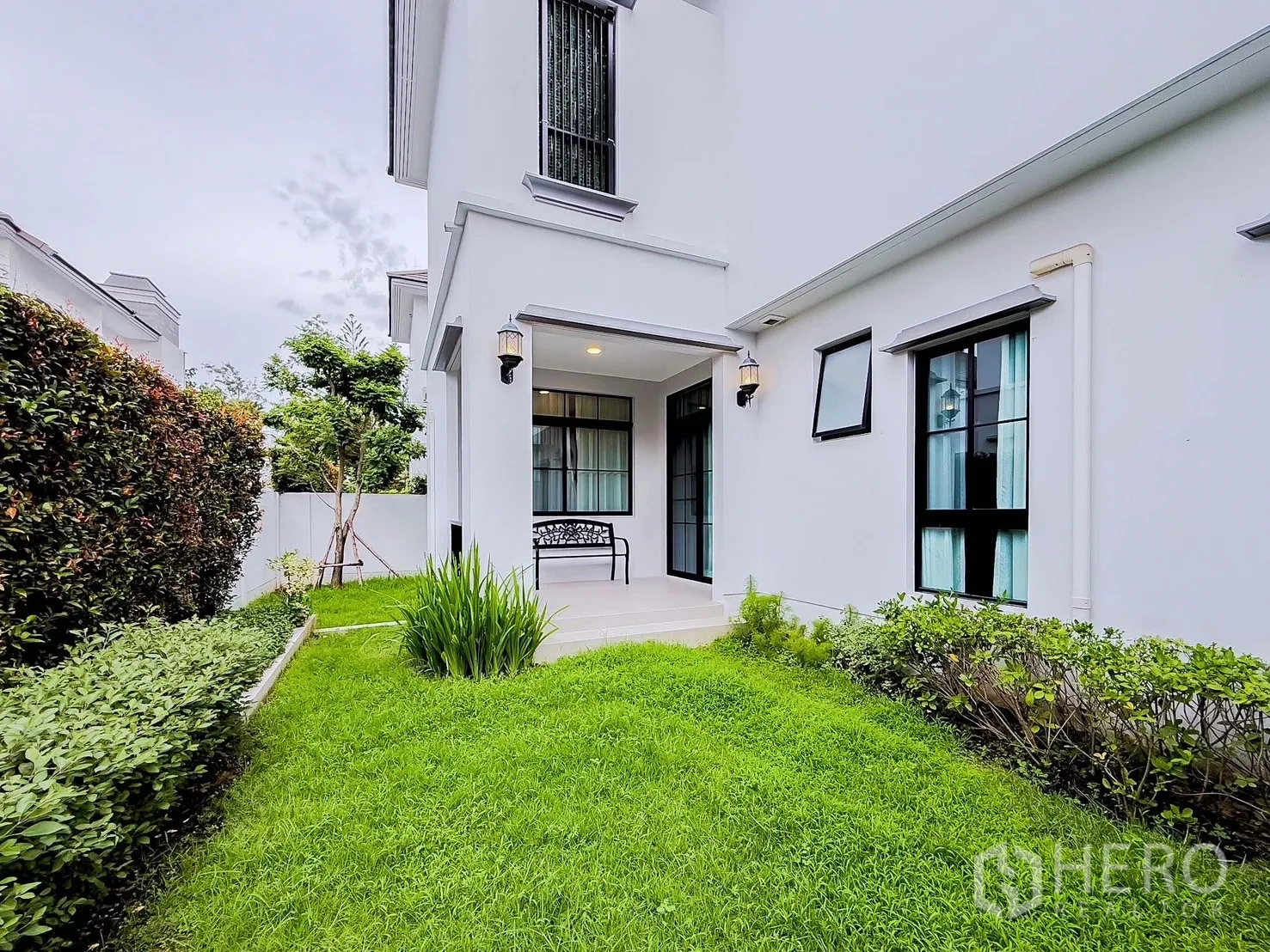 Detached House for rent in Saphan Sung, Bangkok - Covered patio and green yard with hedge fence at the rear side of the home.