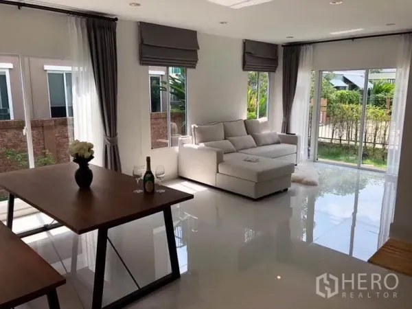 Detached House for rent in Suan Luang, Bangkok - Open-plan living and dining area with large corner windows and glossy floors.
