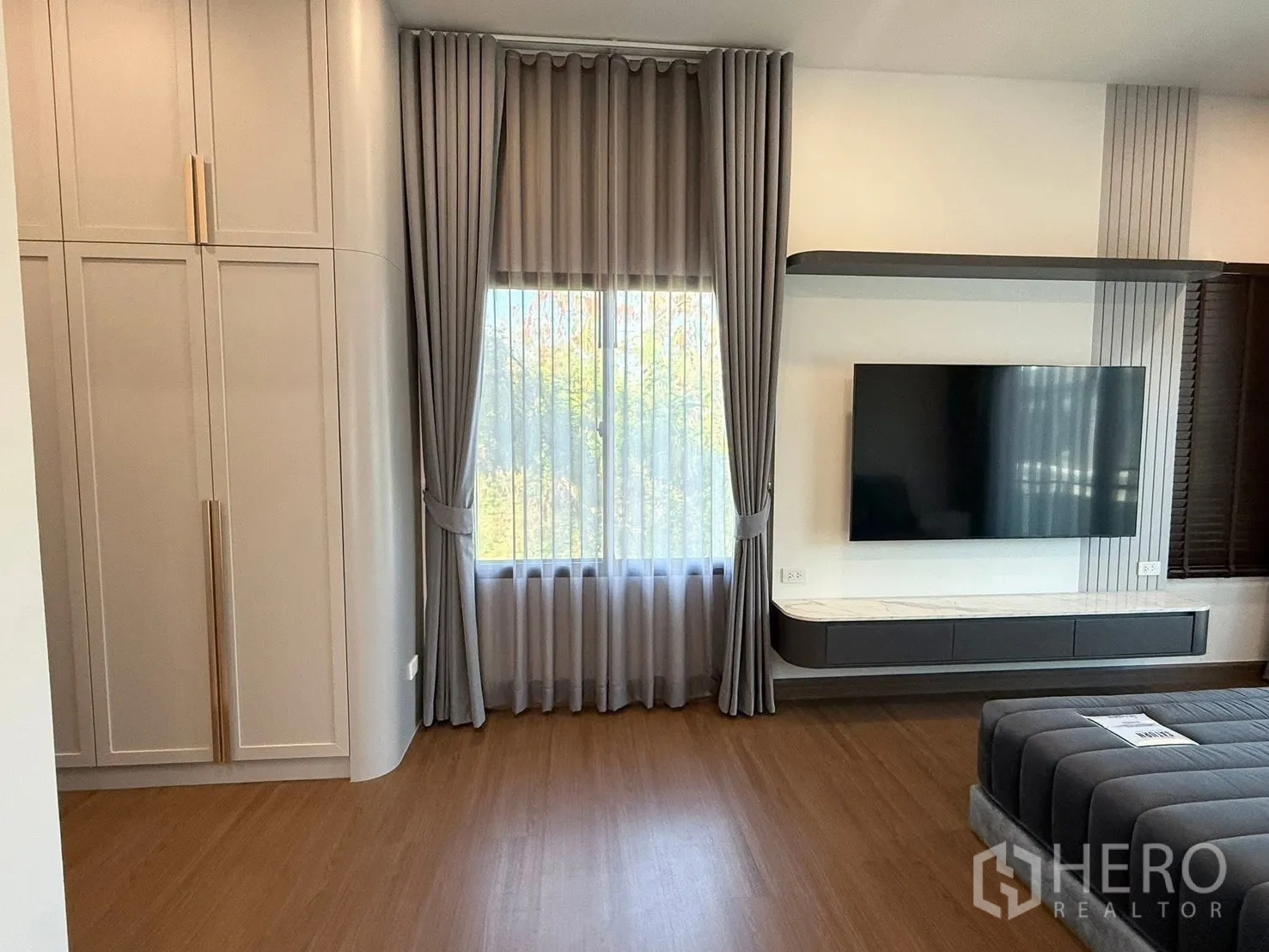 บ้านเดี่ยว for rent in Bang Phli, Samut Prakan - พื้นที่ห้องนอนหลักมีทีวีติดผนังบนผนังตกแต่งและผ้าม่าน.