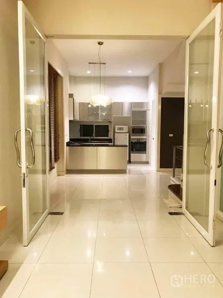 Townhouse for rent in Wang Thonglang, Bangkok - Bright open-plan dining area leading to the kitchen through wide glass doors and pendant lights.