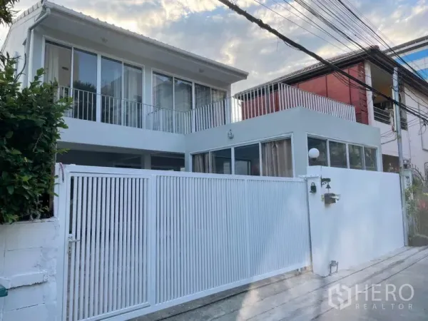 独立式住宅 出租在Huai Khwang, Bangkok - 现代两层独栋住宅，前方白色金属栅栏与大门