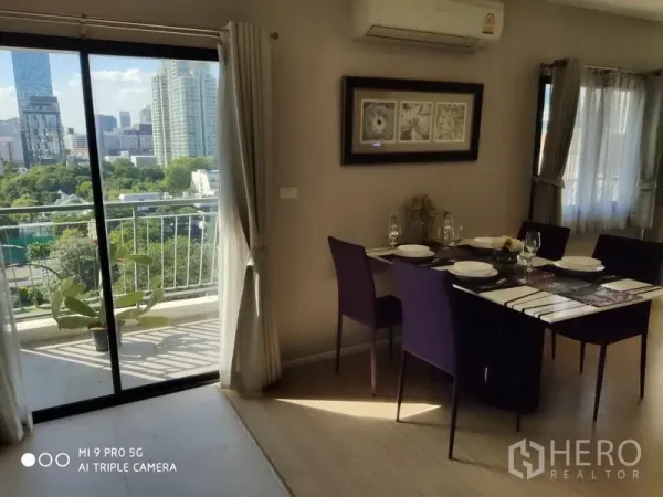 公寓 出租或出售在Pathum Wan, Bangkok - 餐区可坐六人，旁边是通往阳台的推拉门，眺望城市与绿意景观