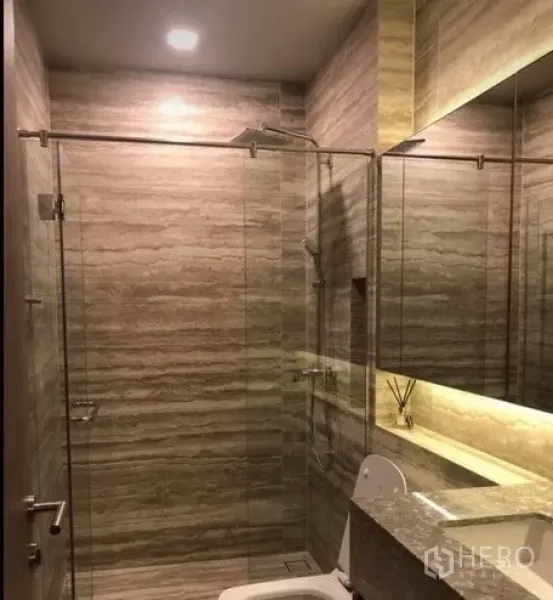 公寓 出租在Watthana, Bangkok - 现代浴室，玻璃淋浴间、石纹瓷砖与背光镜。