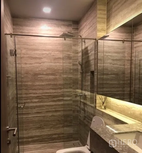 公寓 出租在Watthana, Bangkok - 现代浴室，玻璃淋浴间、石纹瓷砖与背光镜。