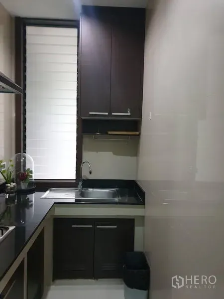 独立式住宅 出售在Watthana, Bangkok - 水槽角落，深色柜体与高窗采光。