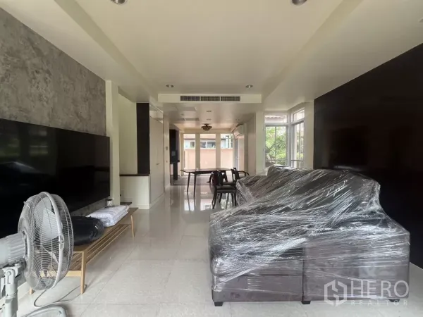 Detached House for rent in Wang Thonglang, Bangkok - Bright open-plan living and dining area with large windows and tiled floors.