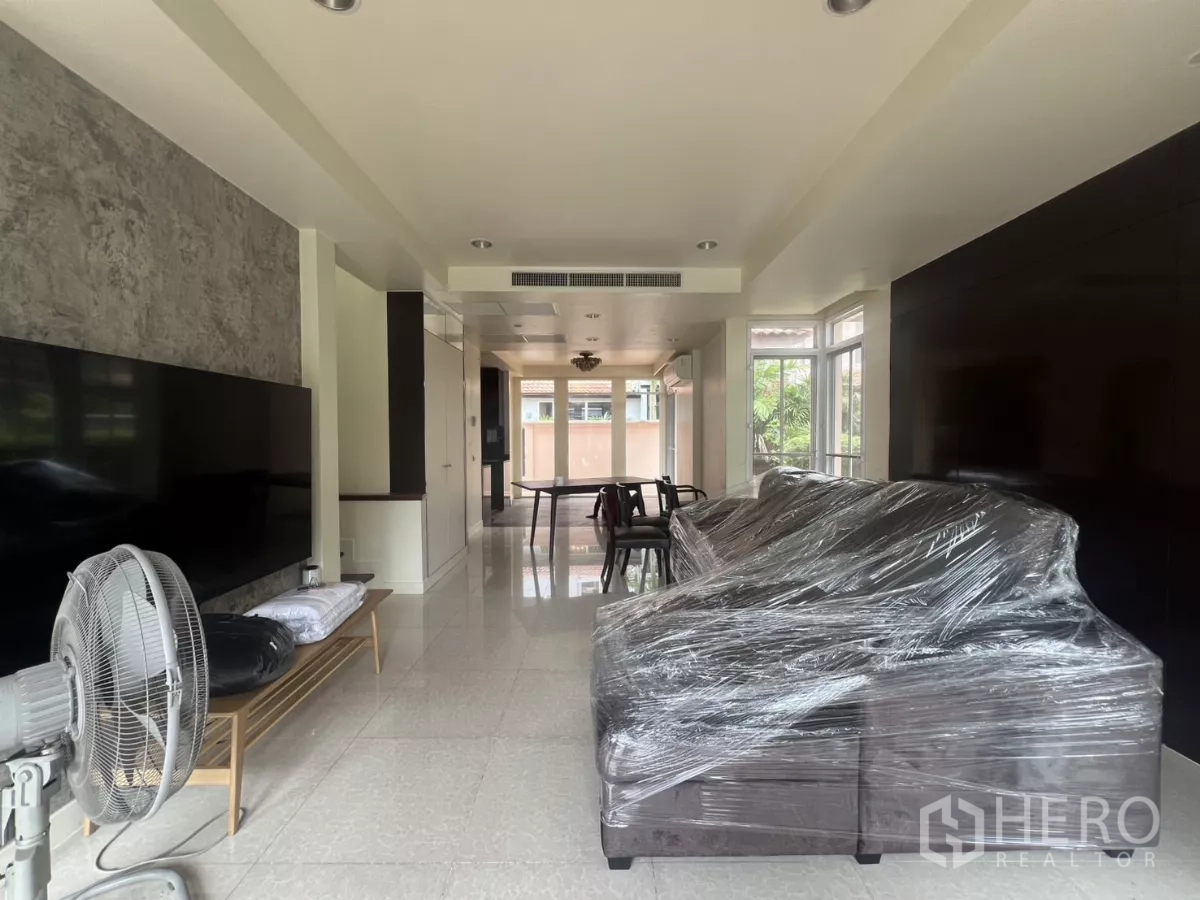 Detached House for rent in Wang Thonglang, Bangkok - Bright open-plan living and dining area with large windows and tiled floors.