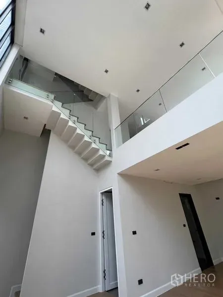 带办公室的家 出售在Wang Thonglang, Bangkok - 室内高挑通透，玻璃栏板楼梯与开放式空间。