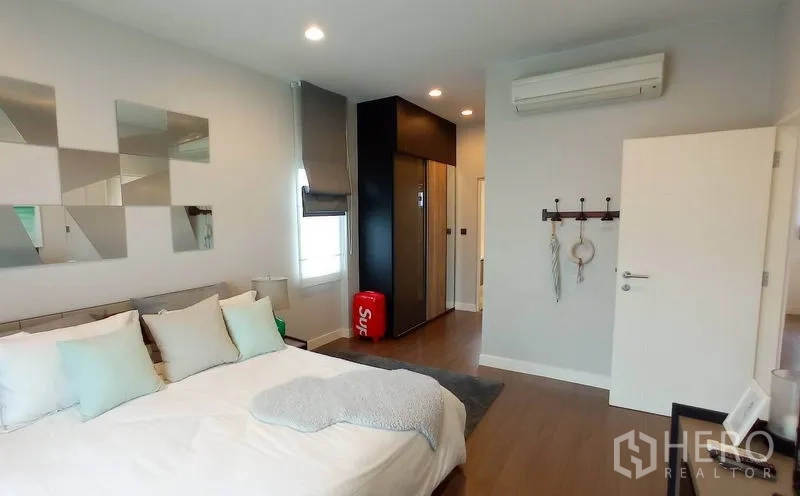独立式住宅 出租在Bang Kapi, Bangkok - 主卧套房，配大床、更衣区、空调与暖色灯光。