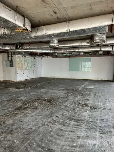 办公空间 出租 - 未配家具的办公室内景，外露管线、白色墙面与水泥地面，适合自行装修。