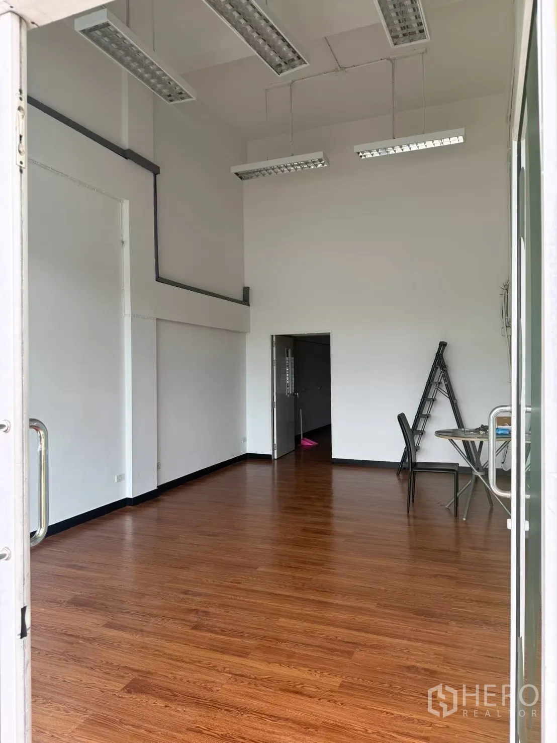 Shophouse for rent in Pak Kret, Nonthaburi - Ground-floor retail space with high ceiling and wood floors.