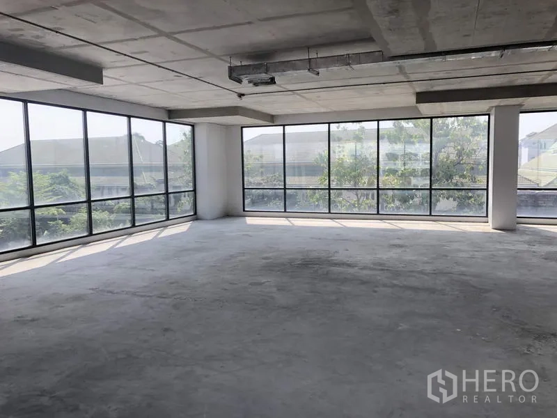 Office Space for rent in Suan Luang, Bangkok - Bright corner zone with floor-to-ceiling glass overlooking trees and neighborhood rooftops.