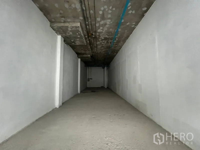 Retail Space for rent in Khlong Toei, Bangkok - Deep rectangular shop space with rough concrete floor and ceiling services visible.