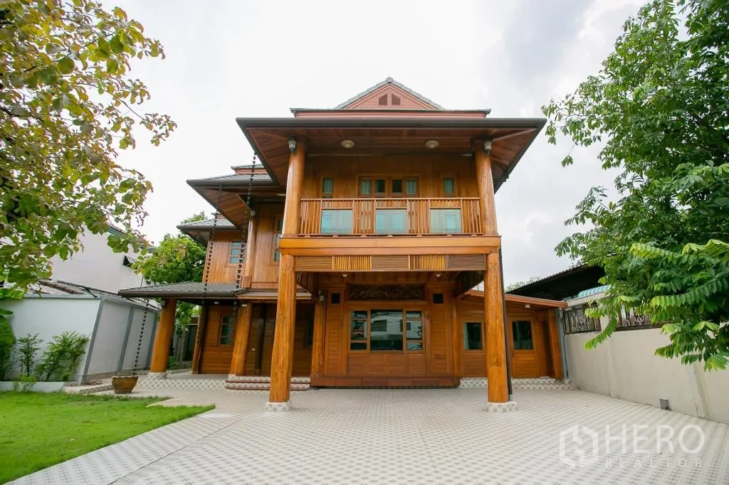 独栋房屋 for rent or sale in Huai Khwang, Bangkok - 房屋正立面，高大木柱与宽阔铺砖前院。