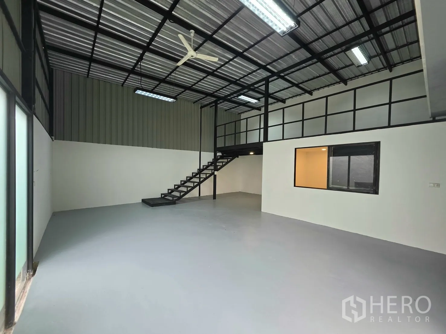 โกดัง for rent in Suan Luang, Bangkok - ภายในโกดังแบบโถงโล่งพร้อมชั้นลอย บันได และไฟส่องสว่าง.
