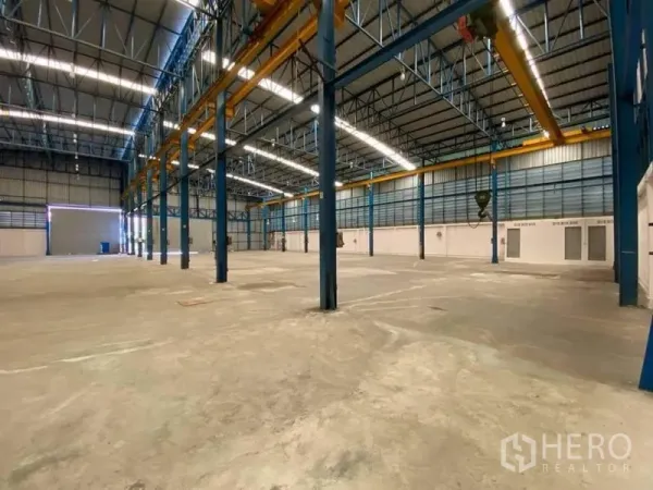 Factory for rent or sale in Bang Sao Thong, Samut Prakan - Open production hall featuring multiple steel columns, wide-span roof and installed crane runway beams.