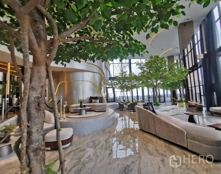 Condominium for rent - Luxury sky lounge lobby with indoor trees, marble floors and floor-to-ceiling windows over Bangkok.