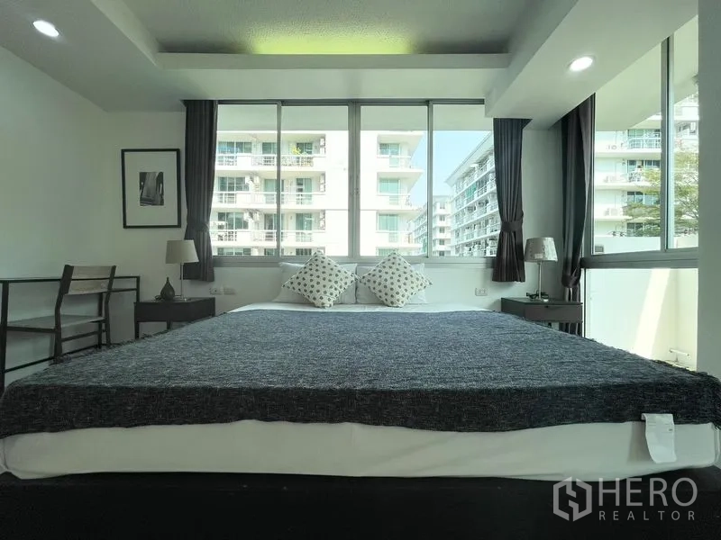 คอนโด for rent in Khlong Toei, Bangkok - มุมหน้าห้องนอน เตียงคิงส์ไซซ์ใต้หน้าต่างบานใหญ่พร้อมผ้าม่าน