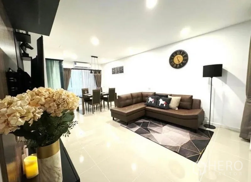 Townhouse for rent - Spacious living room view toward dining area with sectional sofa and neutral tones.