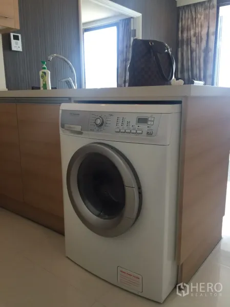 公寓 出租在Khlong Toei, Bangkok - 开放式厨房，浅木色台面下置前置式洗衣机。