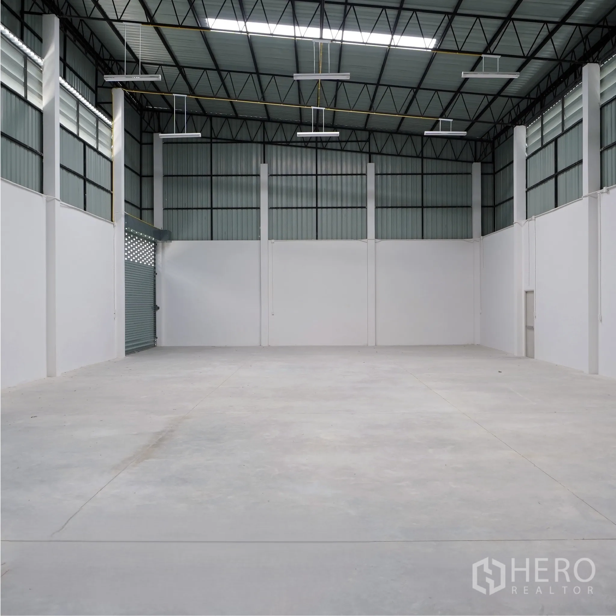 Factory for rent or sale in Bang Len, Nakhon Pathom - Spacious production hall with high ceiling, concrete floor, and roller shutter.