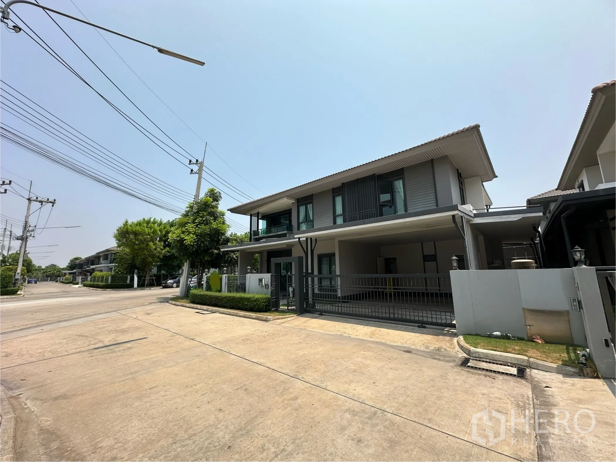 Detached House for rent or sale in Lam Luk Ka, Pathum Thani - Street view of the corner house and quiet gated neighborhood.