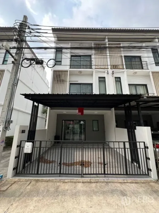 Townhouse for rent in Bang Kapi, Bangkok - Front elevation of three-storey townhouse with gated parking for two cars.