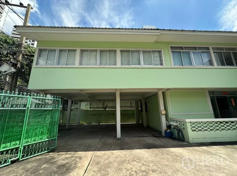 Retail Space for rent in Watthana, Bangkok - Front facade with carport under the second floor and green metal gate.