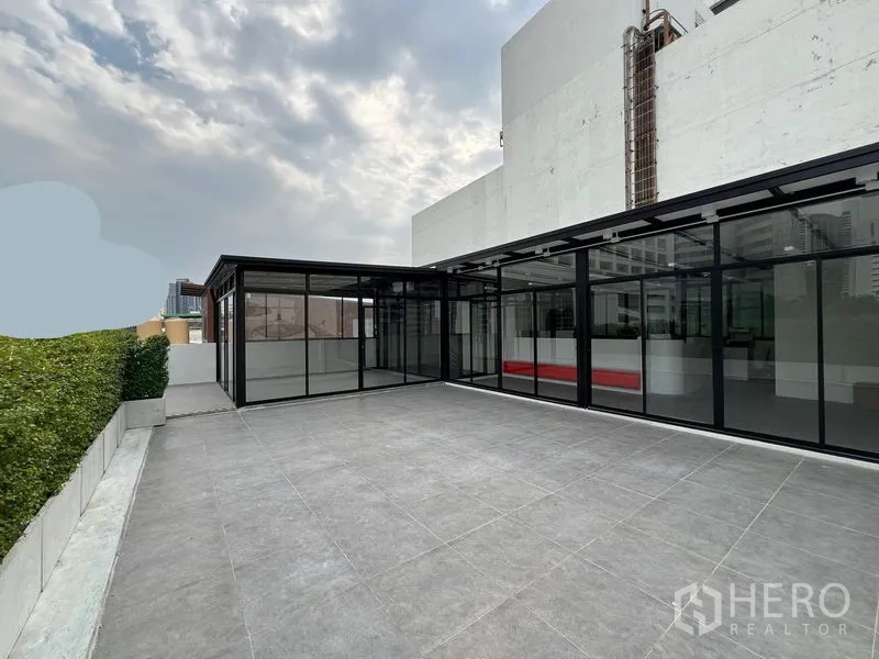 Retail Space for rent in Watthana, Bangkok - Wide rooftop-style tiled terrace next to a contemporary glass-front retail space.