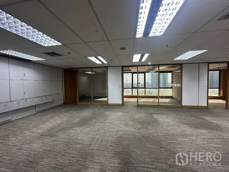 Office Space for rent in Khlong Toei, Bangkok - Corner office area with ceiling lights, glass walls and city views through large windows.
