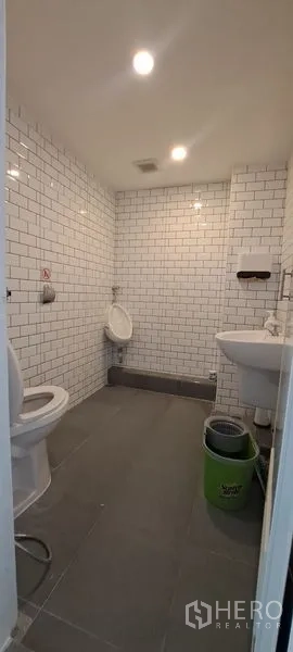 Retail Space for rent in Bang Rak, Bangkok - Clean restroom with white subway tiles, toilet, urinal and sink.