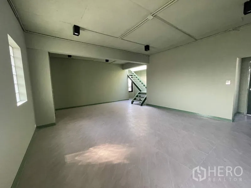 Home Office for rent in Phaya Thai, Bangkok - Flexible room with internal metal staircase and soft green walls.