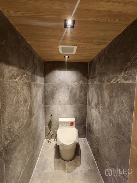 Retail Space for rent in Pathum Wan, Bangkok - Modern toilet cubicle with grey tiles and recessed lighting.