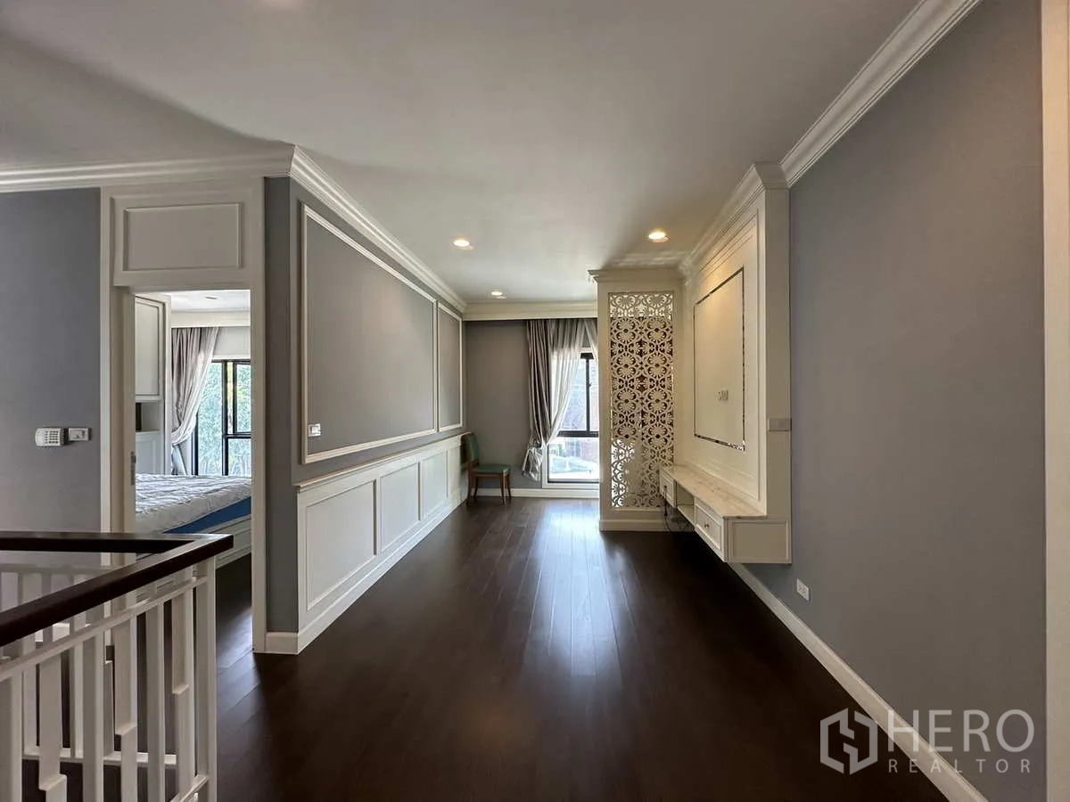 Detached House for rent or sale in Lam Luk Ka, Pathum Thani - Upstairs landing with dark wood floor and decorative panel.