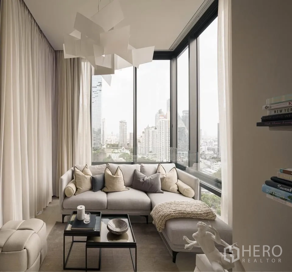 公寓 for rent in Bang Rak, Bangkok - 转角客厅设L型沙发，落地窗外是城市全景。