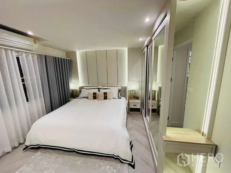 公寓 出售在Yan Nawa, Bangkok - 宽敞主卧，白色床品、背光床头板与镜面衣柜。