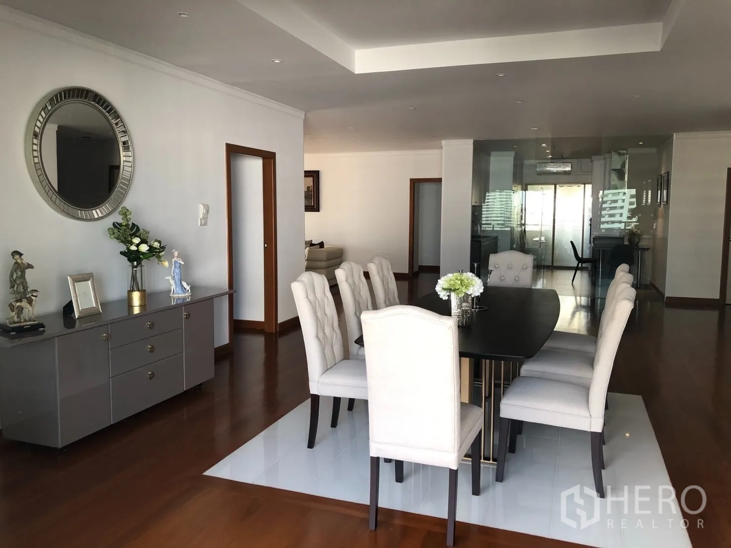 Condominium for rent in Bangkok - Dining area with sideboard and view toward the glass-enclosed kitchen.