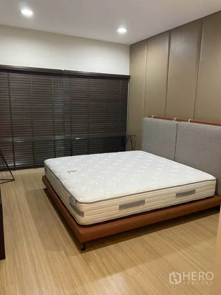 公寓 出租在Khlong Toei, Bangkok - 主卧空间宽敞，大床、软包床头与宽幅百叶窗。