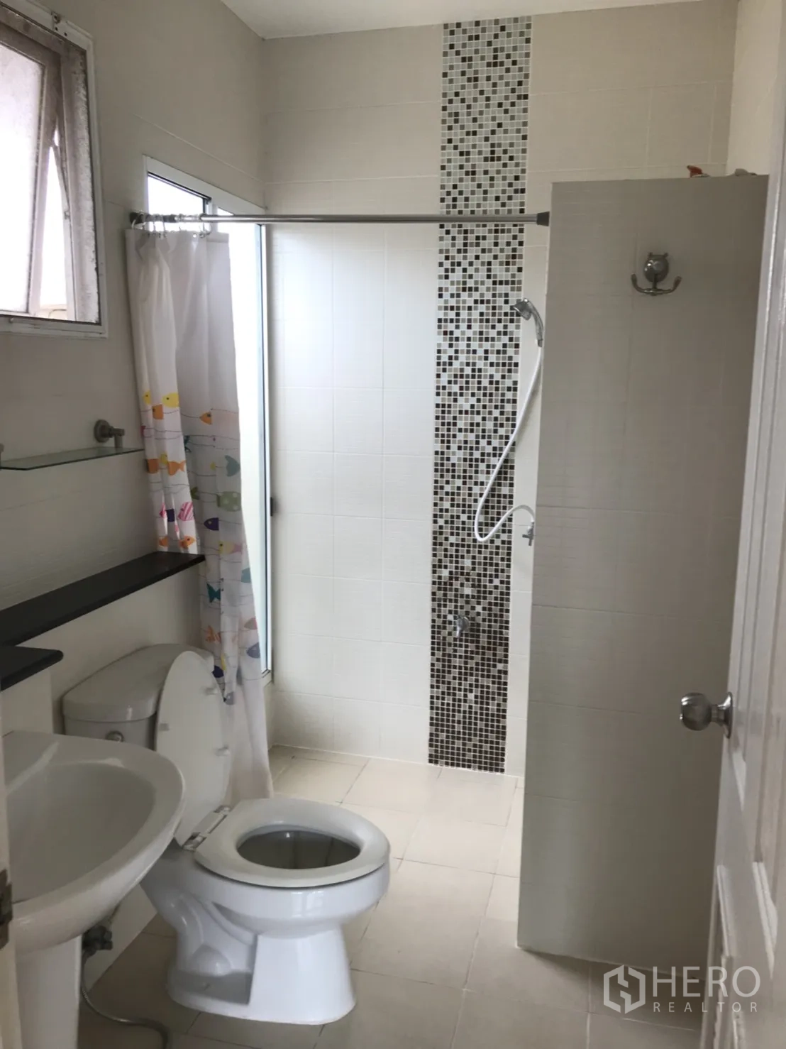 Detached House for rent in Lat Krabang, Bangkok - Bathroom with shower, mosaic accent strip, white fixtures and a window for ventilation.