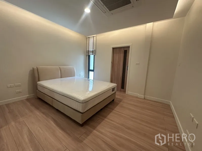 联排别墅 出租在Watthana, Bangkok - 温馨卧室，软包床、木地板与套内门