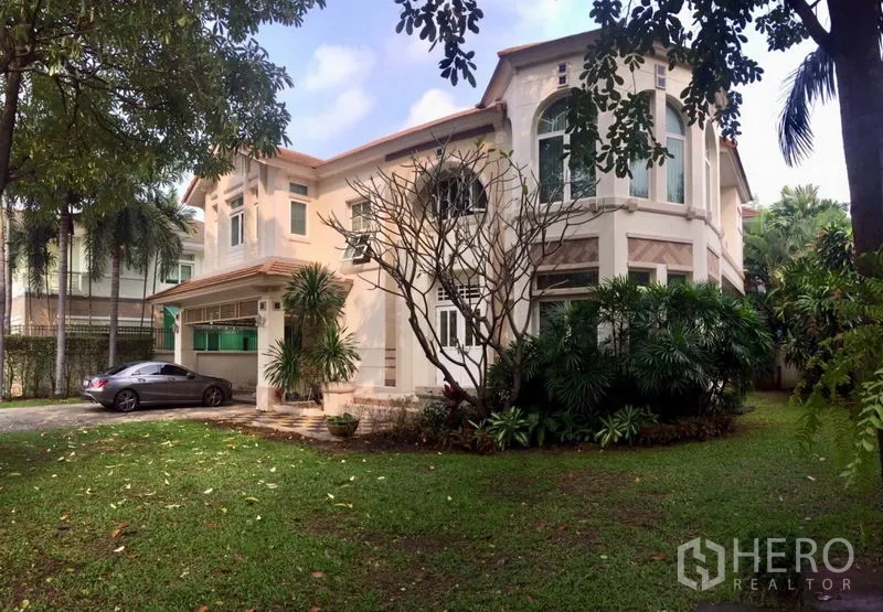 Detached House for rent or sale in Lat Phrao, Bangkok - Two-storey detached house exterior with driveway parking and landscaped lawn.