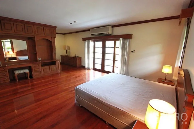 独立式住宅 出租在Prawet, Bangkok - 卧室带实木地板、梳妆内置柜，推拉玻璃门连阳台，带空调。