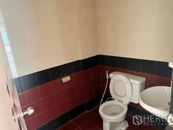 办公空间 出租在Pathum Wan, Bangkok - 紧凑的办公卫生间，配洗手盆与马桶，红黑拼色瓷砖墙面。