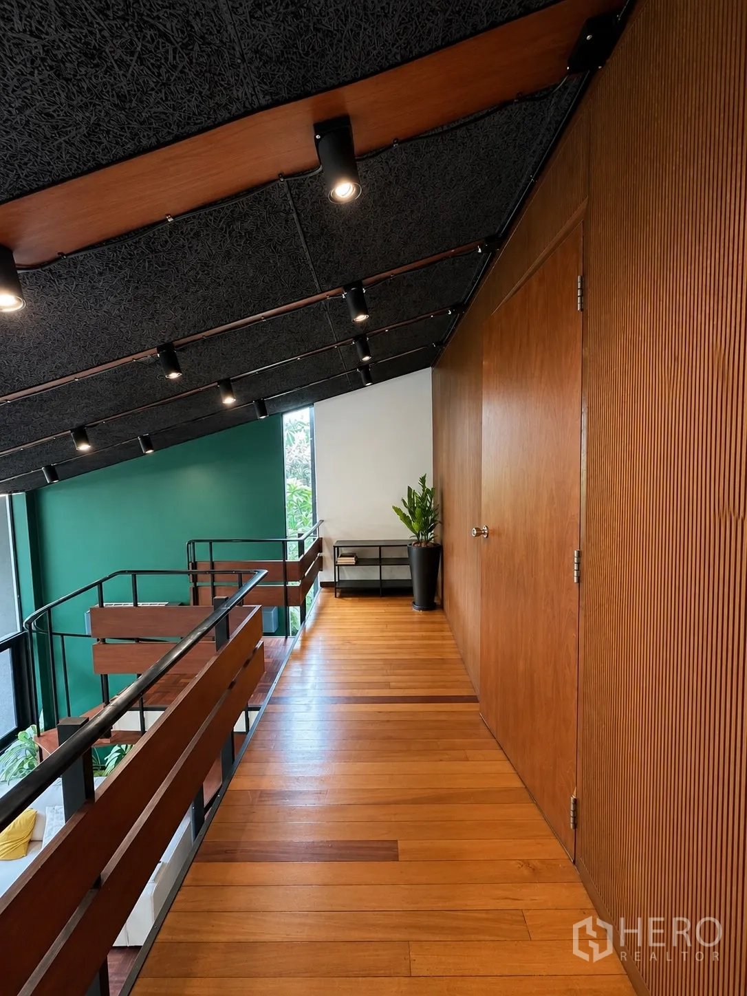 Office Space for rent in Phaya Thai, Bangkok - Mezzanine corridor with wood flooring, black railing, and spotlights.
