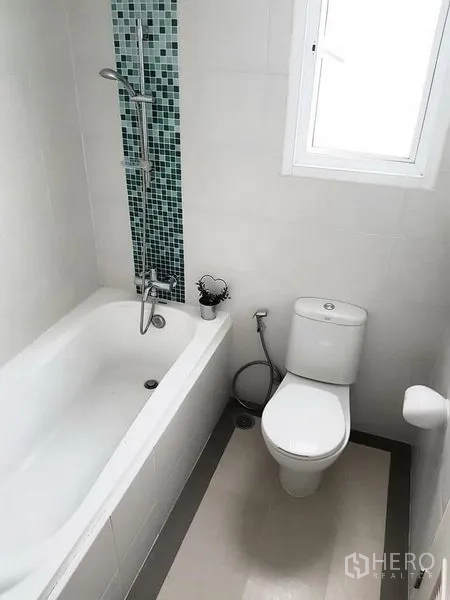 Condominium for rent in Phaya Thai, Bangkok - Clean bathroom featuring a bathtub, shower set and a window for natural light.
